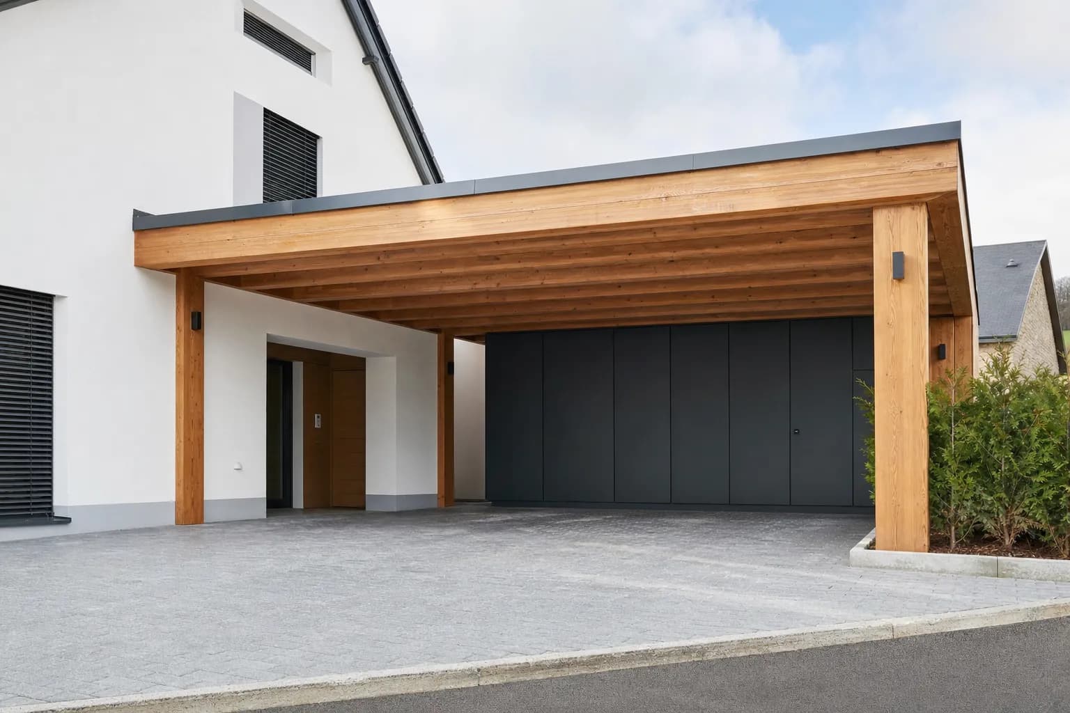 Bespoke timber carport and adjoining timber terrace at a detached house, built by Blang Holzbau