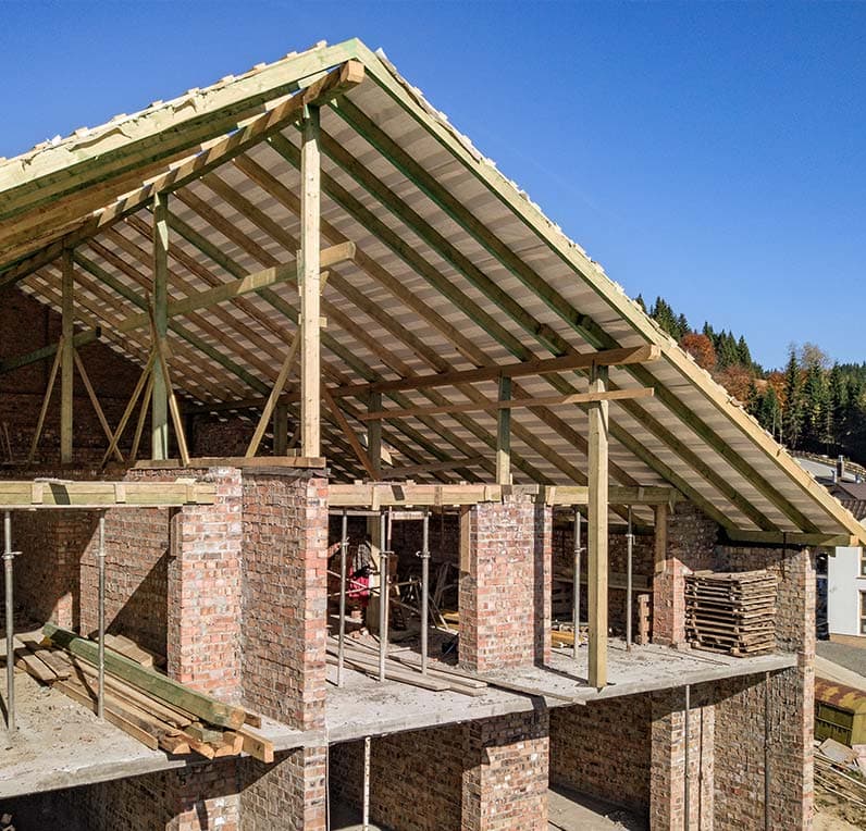 Blang Holzbau carpenters installing a prefabricated timber-frame wall on a construction site in Luxembourg
